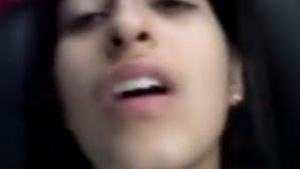 A charming Indian girl engages in solo sex acts inside a car