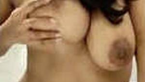 A Tamil woman with large breasts displays them in a sensual video