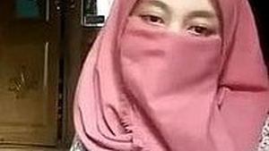 A girl wearing a hijab strips on webcam