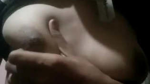 A woman from the Indian subcontinent squeezes her own breasts