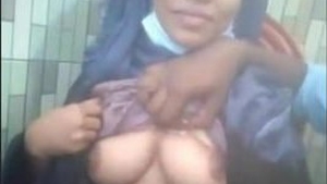 A girl wearing a hijab reveals her large breasts and receives oral pleasure from her partner in a restaurant